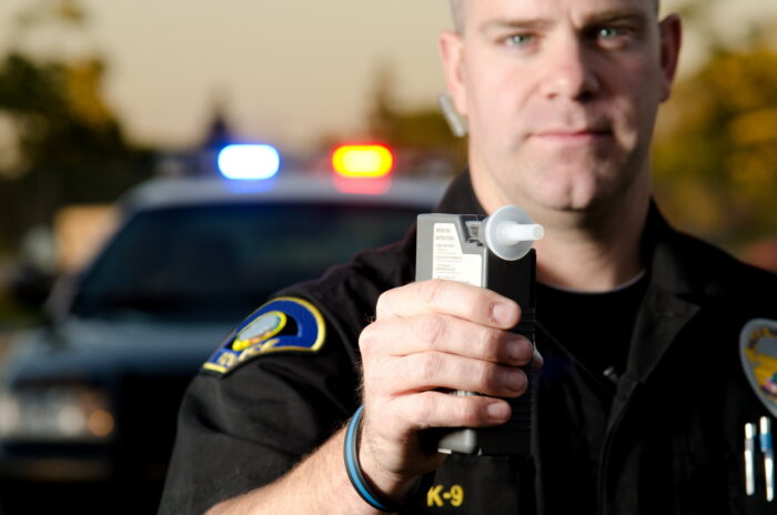 Police officer issuing a breathalyzer test.